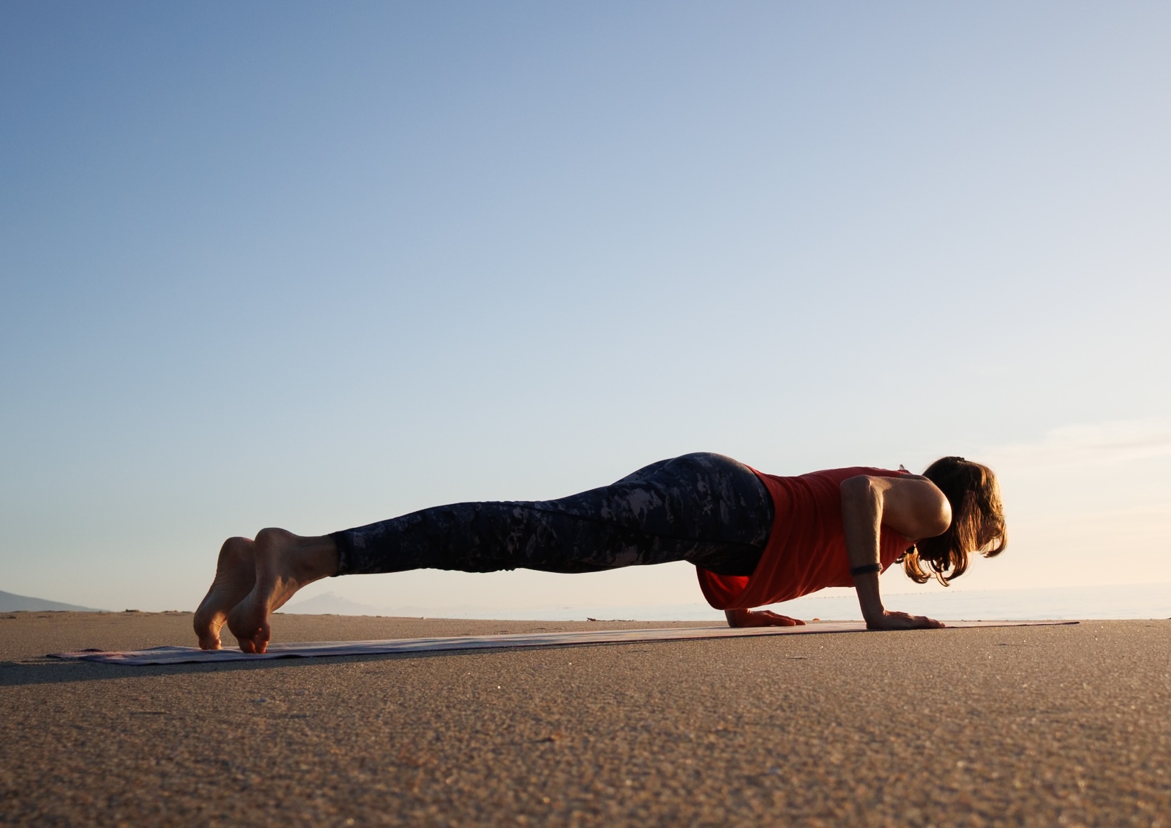 Liegestütz tief haltend am Strand