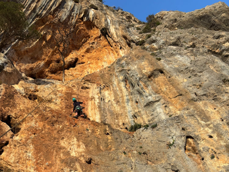 Kletterin am gold gelb leuchtenden Fels im Sektor Rainbow in Manikia in Griechenland