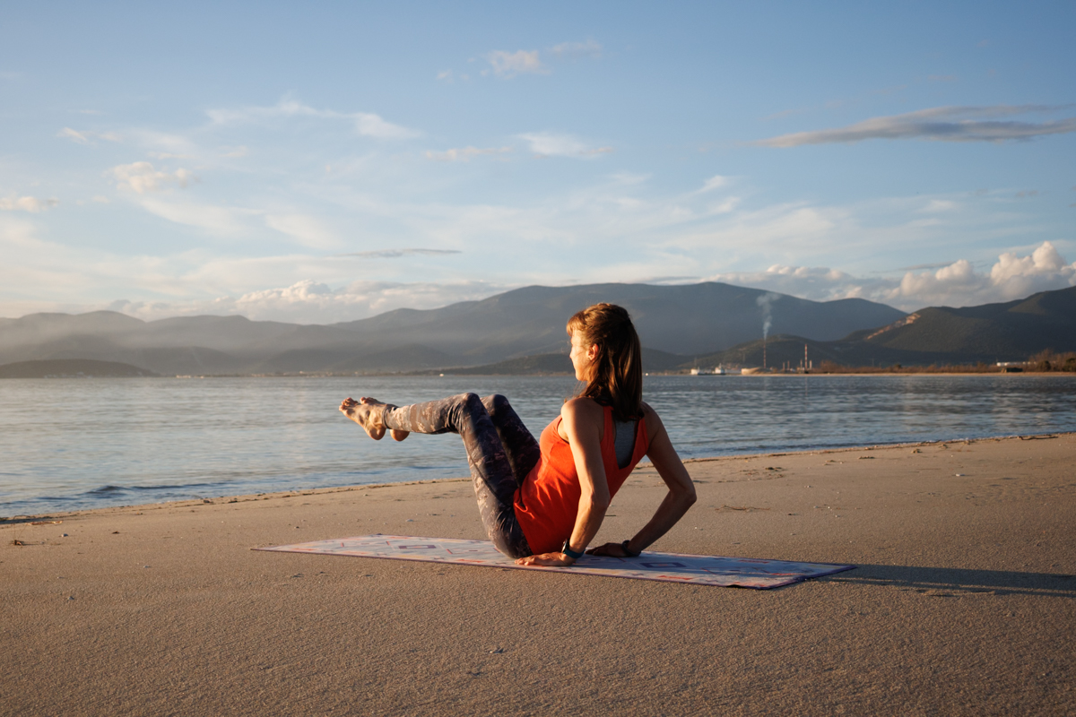 Personal Trainerin am Strand macht Bauchtraining