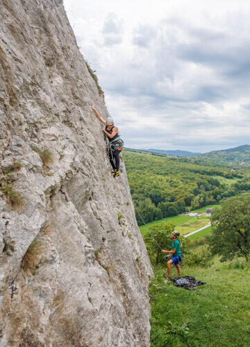 Kletterin fokussiert bei Plattenkletteri in Ampoita, Rumänien