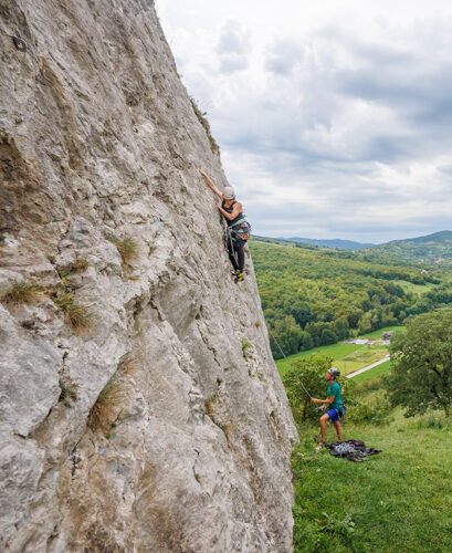 Kletterin fokussiert bei Plattenkletteri in Ampoita, Rumänien