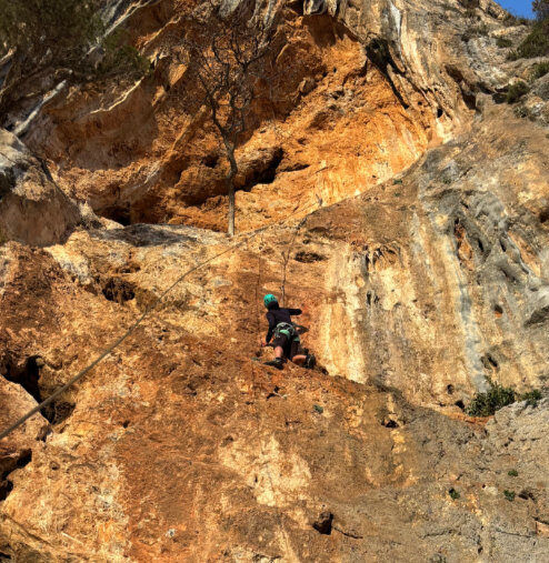 Kletterin am gold gelb leuchtenden Fels im Sektor Rainbow in Manikia in Griechenland